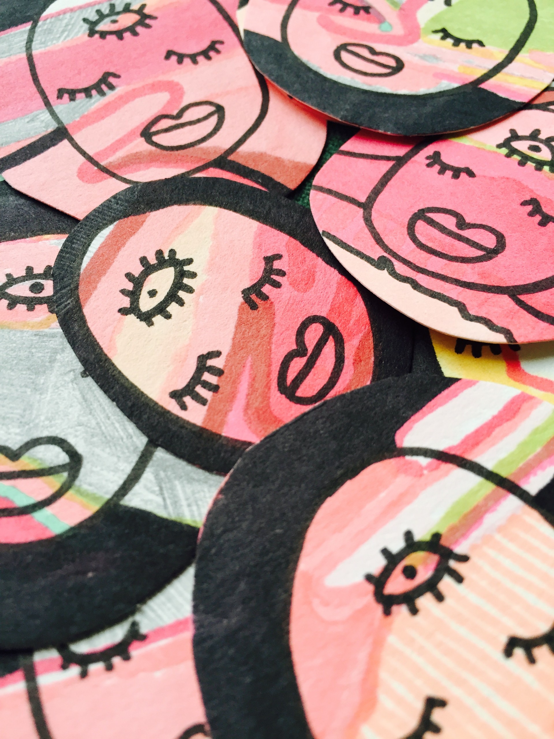 Pile of stickers. Stickers are of faces with third eye. 