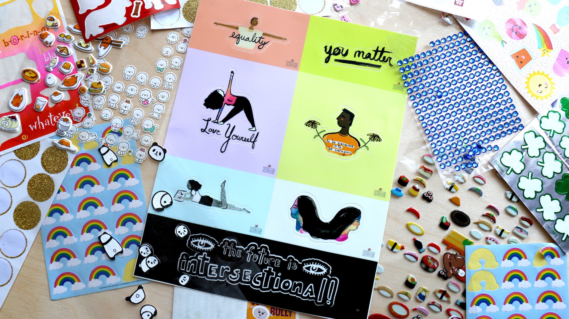 Various sticker sheets spread on wooden table. 