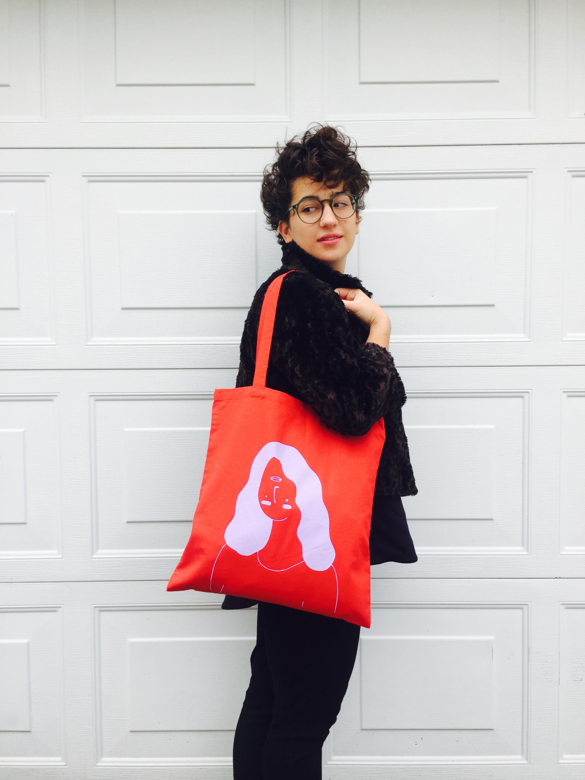 Red tote bag with a girl printed in lavender whose facial features are upside down 