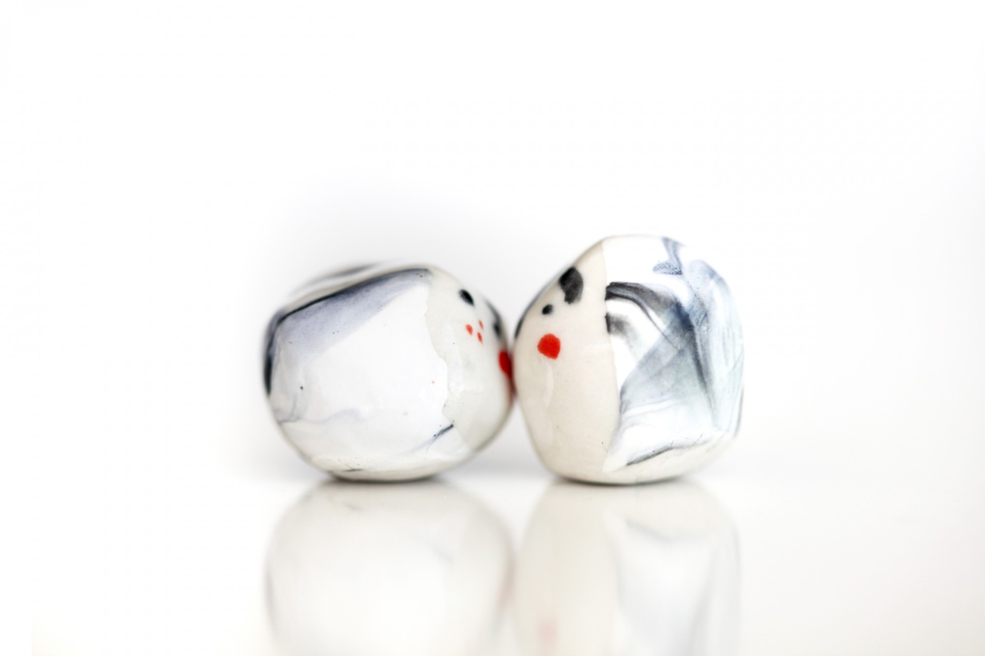 Two porcelain heads kissing on white background. 