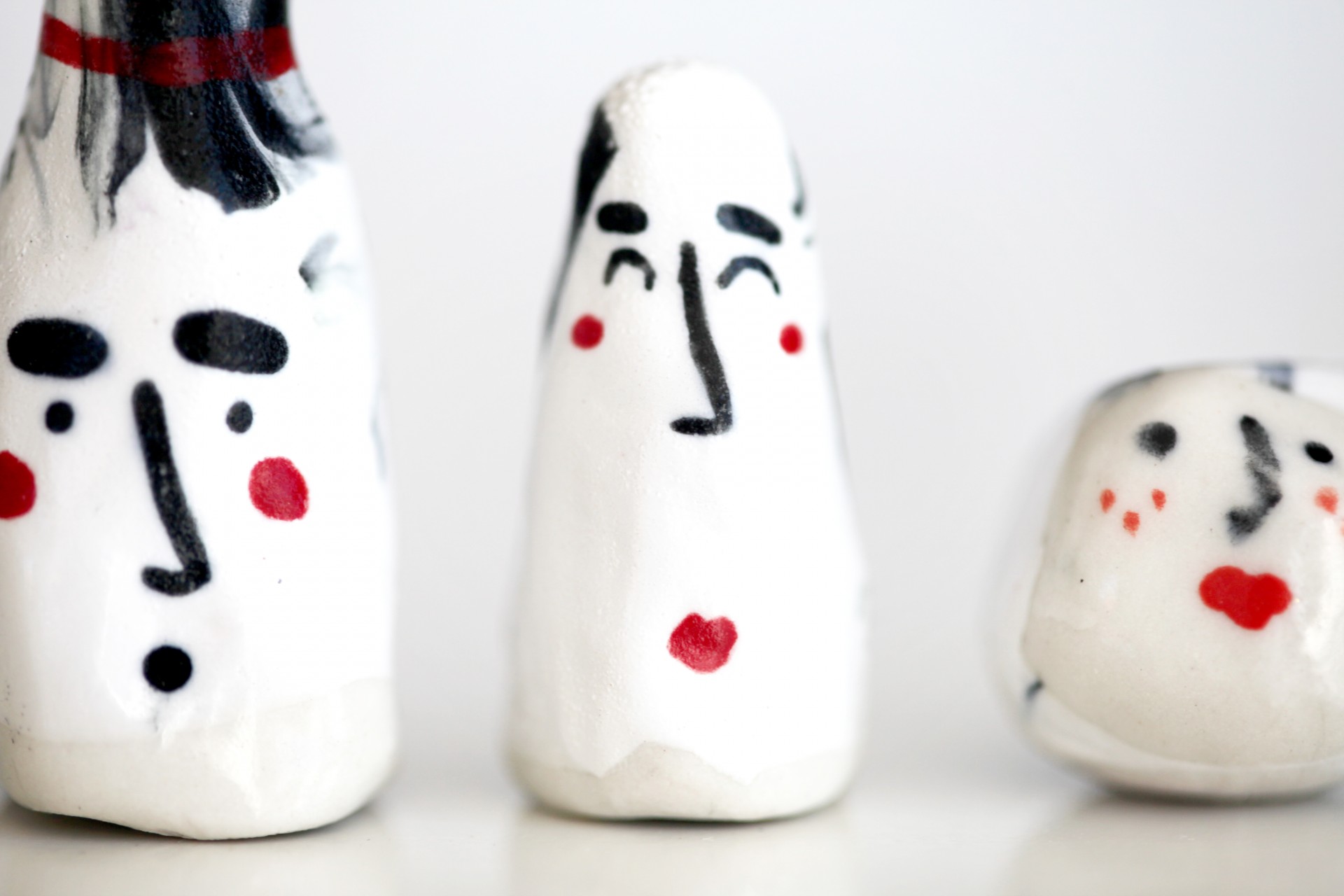 Close up of three porcelain heads in a row on white background. 
